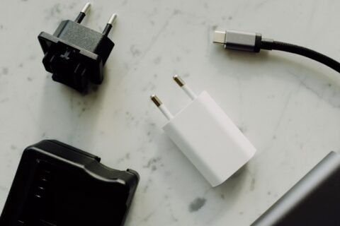 Pilihan adaptor daya dan kabel USB-C di atas permukaan meja.