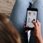 Seseorang melihat daftar produk pakaian di smartphone saat berbelanja online