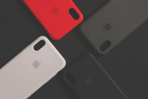 Empat casing iPhone dengan warna dan desain berbeda diletakkan di atas permukaan gelap.